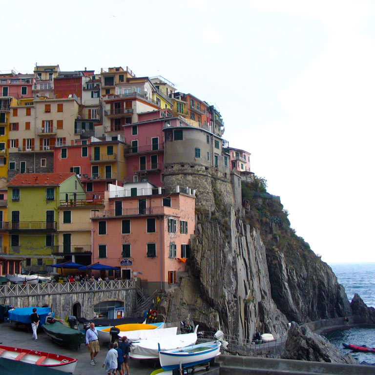 Boats and houses built into the side of a cliff