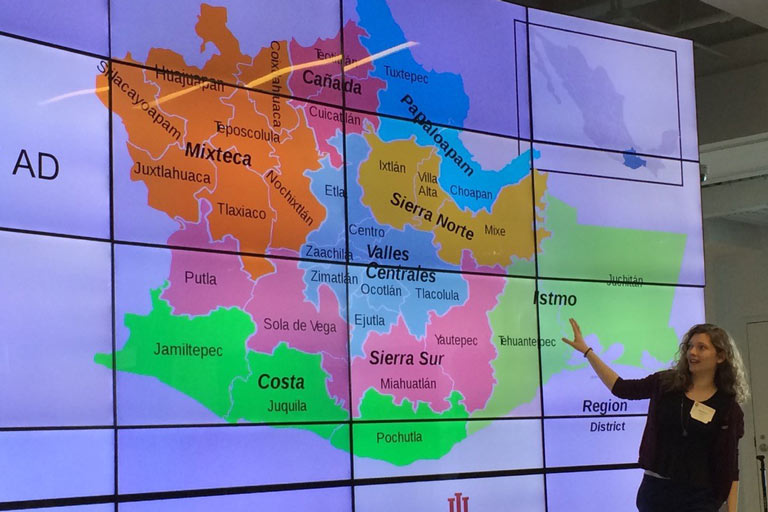 A woman references a map on a screen