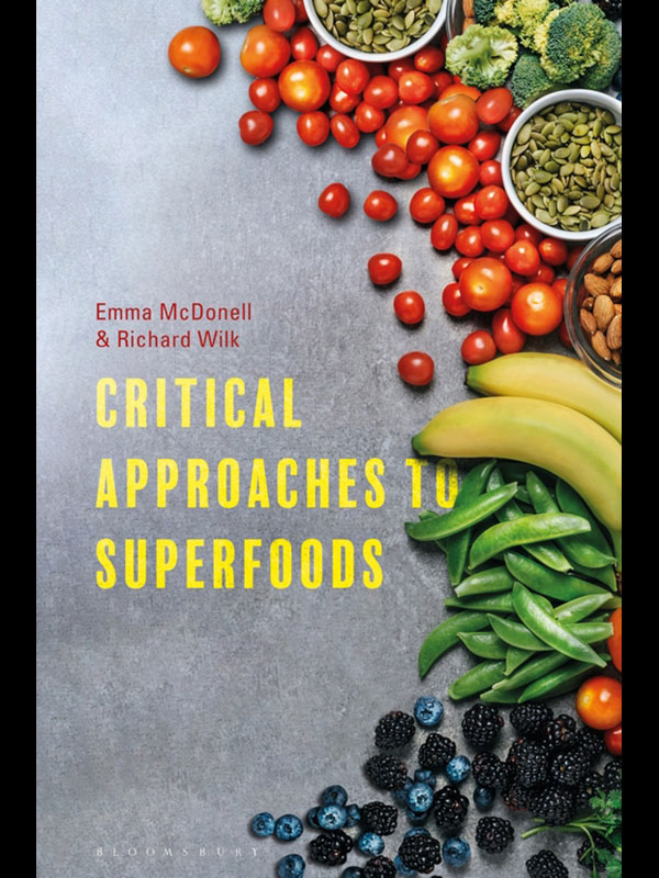 The book cover of Critical Approaches to Superfoods, which depicts a countertop with fruits and vegetables scattered over it.