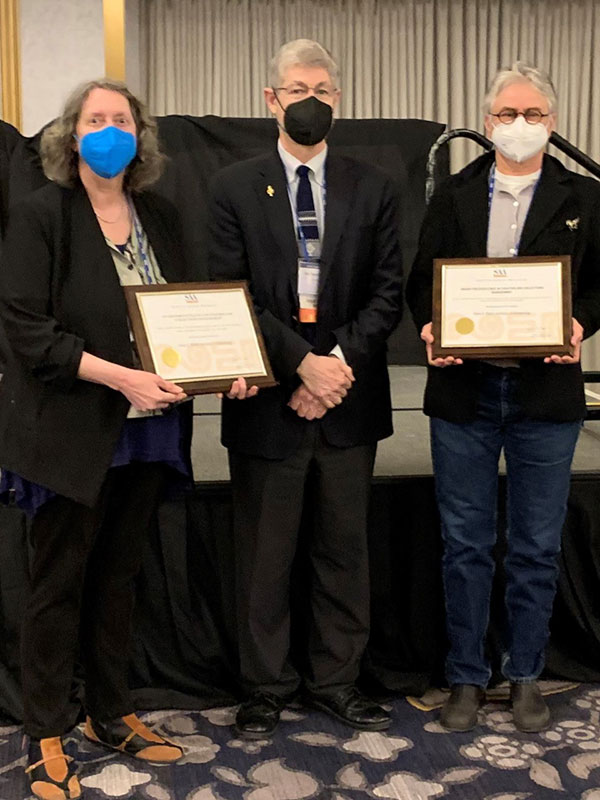 A picture of Professor April Sievert posing with two colleagues. All three wear COVID masks.