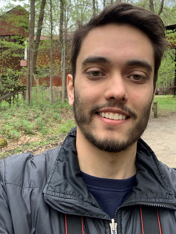 A headshot of graduate student Benjamin Ale-Ebrahim, who poses outdoors and wears a black winter coat.