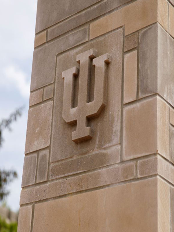 The IU trident embossed in a limestone column.
